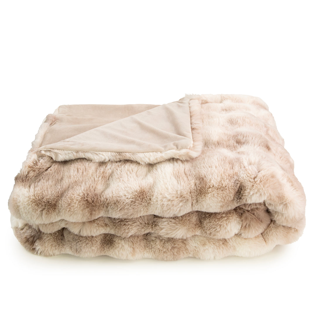 Folded beige and brown faux fur throw blanket on a white background