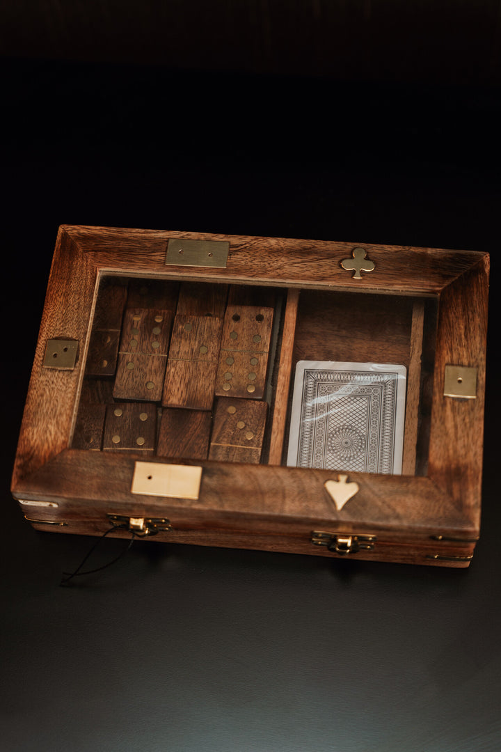 Wooden box with compartments and a deck of cards on a dark background