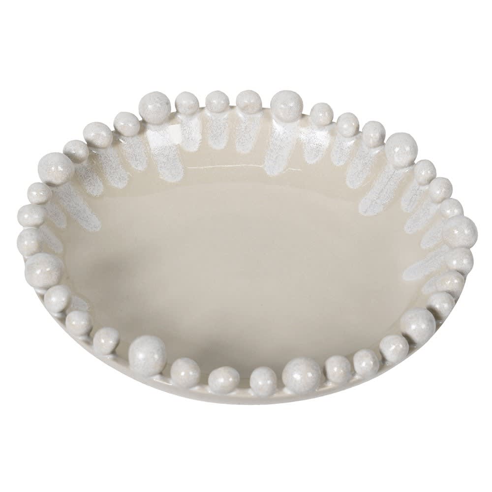 An oval ceramic dish with a glossy cream finish, featuring a raised border of white beads and textured white drips around the rim, shown on a plain white background.