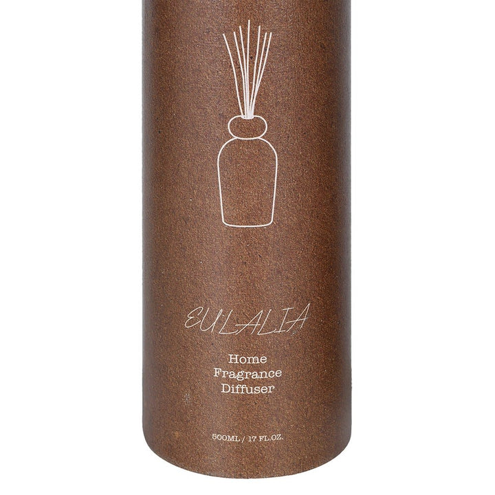 A cylindrical brown diffuser container with a white line drawing of a reed diffuser and the text &