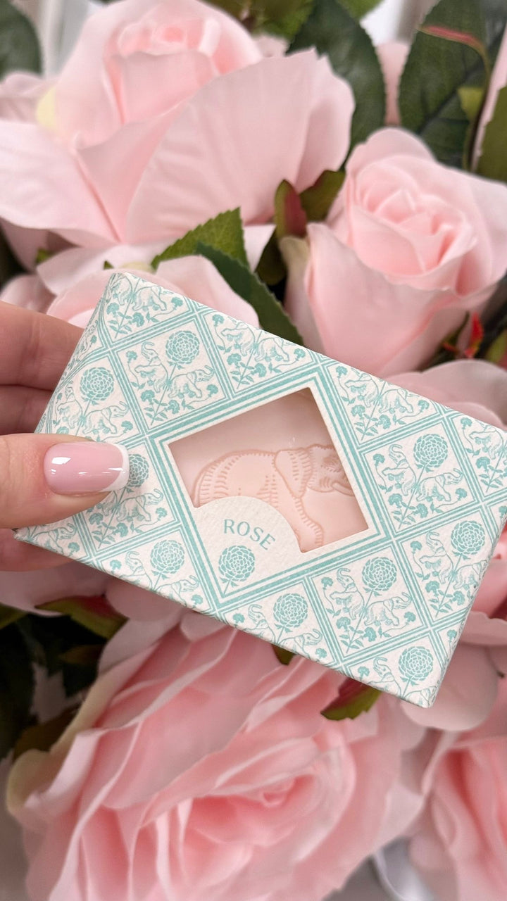 Decorative box with floral design held among pink roses