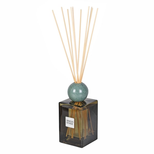 A reed diffuser with a square dark glass bottle, a round teal-green ceramic sphere, and natural bamboo reeds, shown on a plain white background. A white label on the bottle reads &