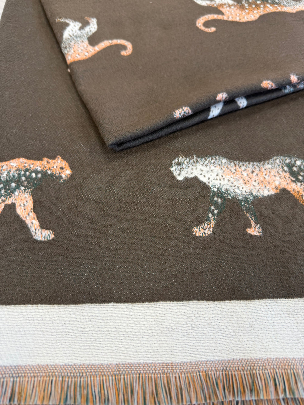 Textile with animal pattern and fringe detail