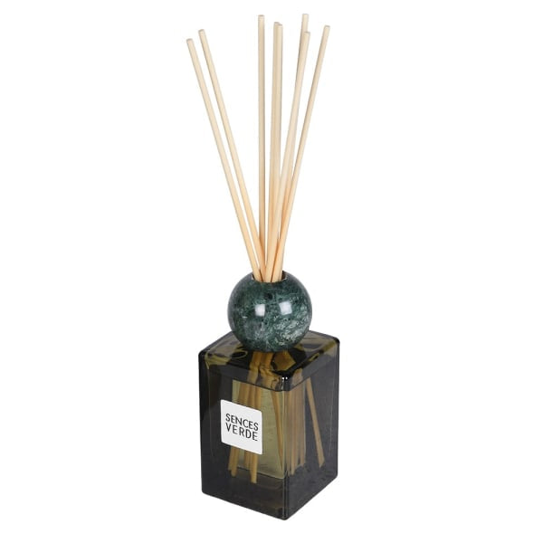 A reed diffuser with a dark green marble sphere and natural wood reeds, set in a square translucent black glass bottle with a white label reading 'SANCES VERDE'.