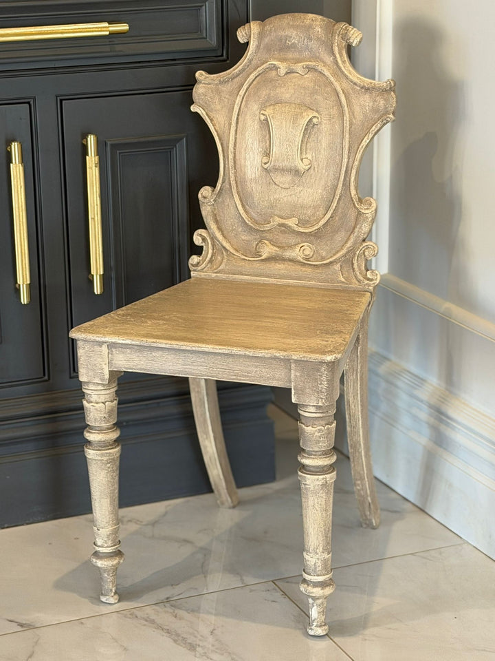 Refurbished Antique Crest Chair
A beautifully elegant piece, this refurbished antique crest chair is full of charm, character, and timeless appeal.
Featuring an ornate carved backrest with a striking central crest detail, this chair showcases classic craftsmanship paired with a soft, neutral washed finish — making it perfect for both traditional and modern interiors. The turned legs and delicate shaping add to its refined silhouette, while the aged texture enhances its authentic antique feel.
Carefully rest