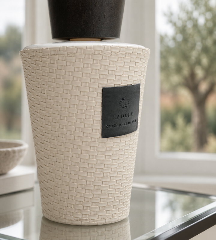 A textured cream-colored ceramic vase with a woven basket pattern, featuring a black label that reads &
