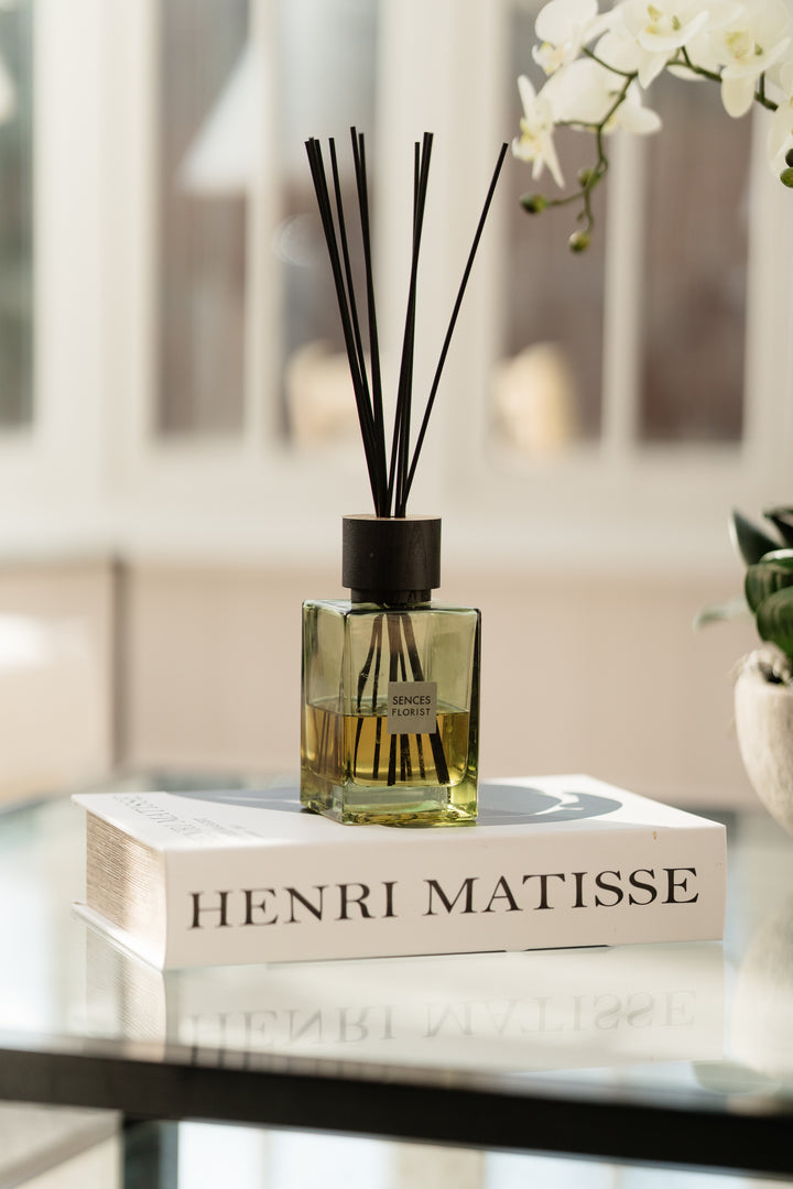 Diffuser with sticks on a book titled &