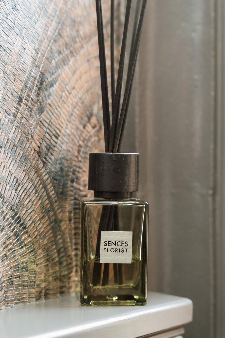 Senses Florist diffuser bottle on a surface with a textured wall background