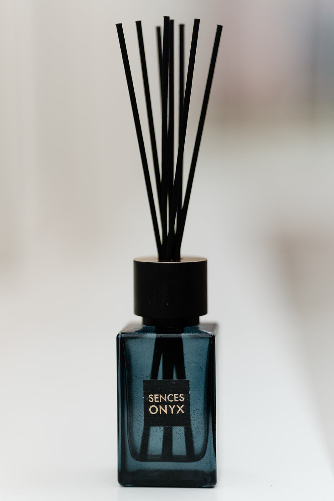 Diffuser bottle labeled 'Onyx' with black sticks on a blurred background