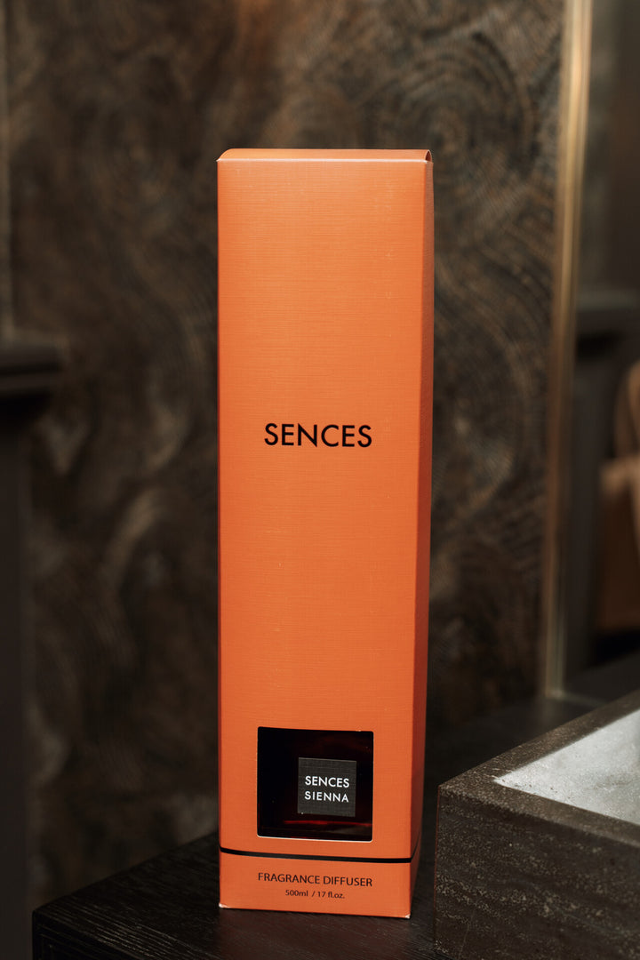 Orange Sences fragrance diffuser box on a dark surface with a blurred background