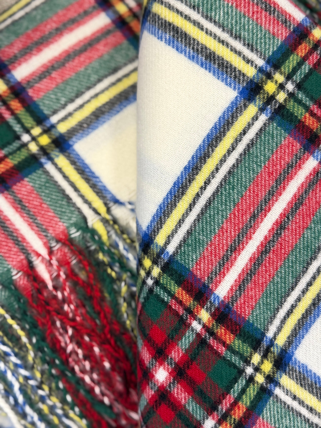 Close-up of multicolored plaid fabric with red, green, blue, and yellow stripes.