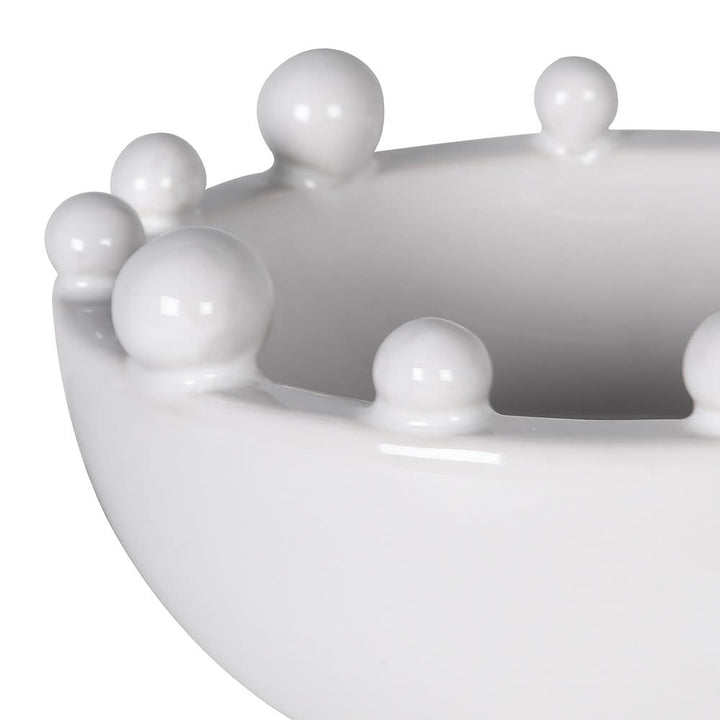 White ceramic bowl with spherical protrusions on a white background